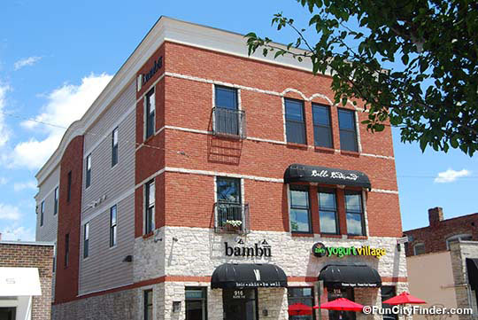 Photograph of a beautiful brick building filled with Indianapolis shopping options like the Bambu cosmetic store in Broad Ripple Village