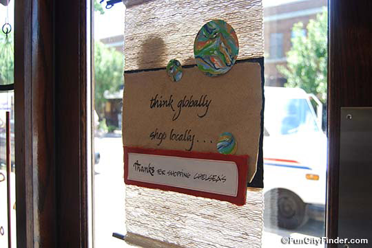 Photograph of the Think Globally, Shop Locally sign on the door of the Chelsea's store in Broad Ripple Village